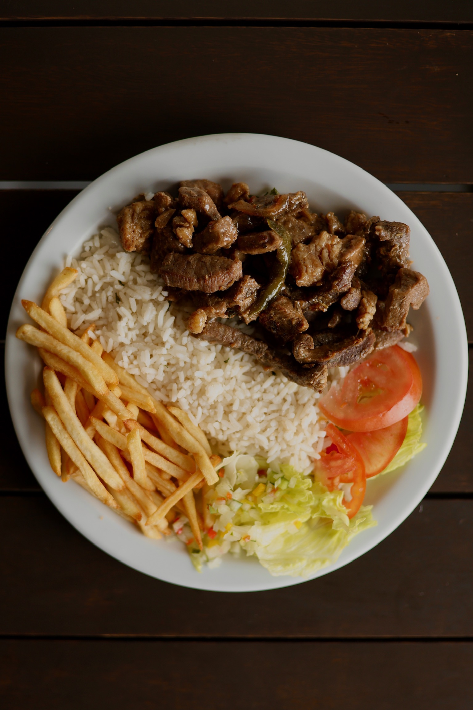 Prato feito com carne, arroz, fritas e salada